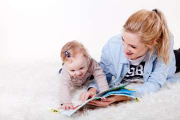 Au-pair-tjej som läser för ett barn